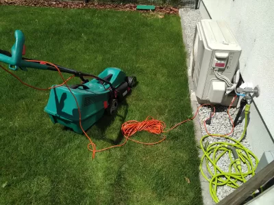5 Best Lawn Mowers For Your Small Garden &ndash; Buying Guide : A BOSCH electric lawn mower plugged outdoor on a small garden lawn