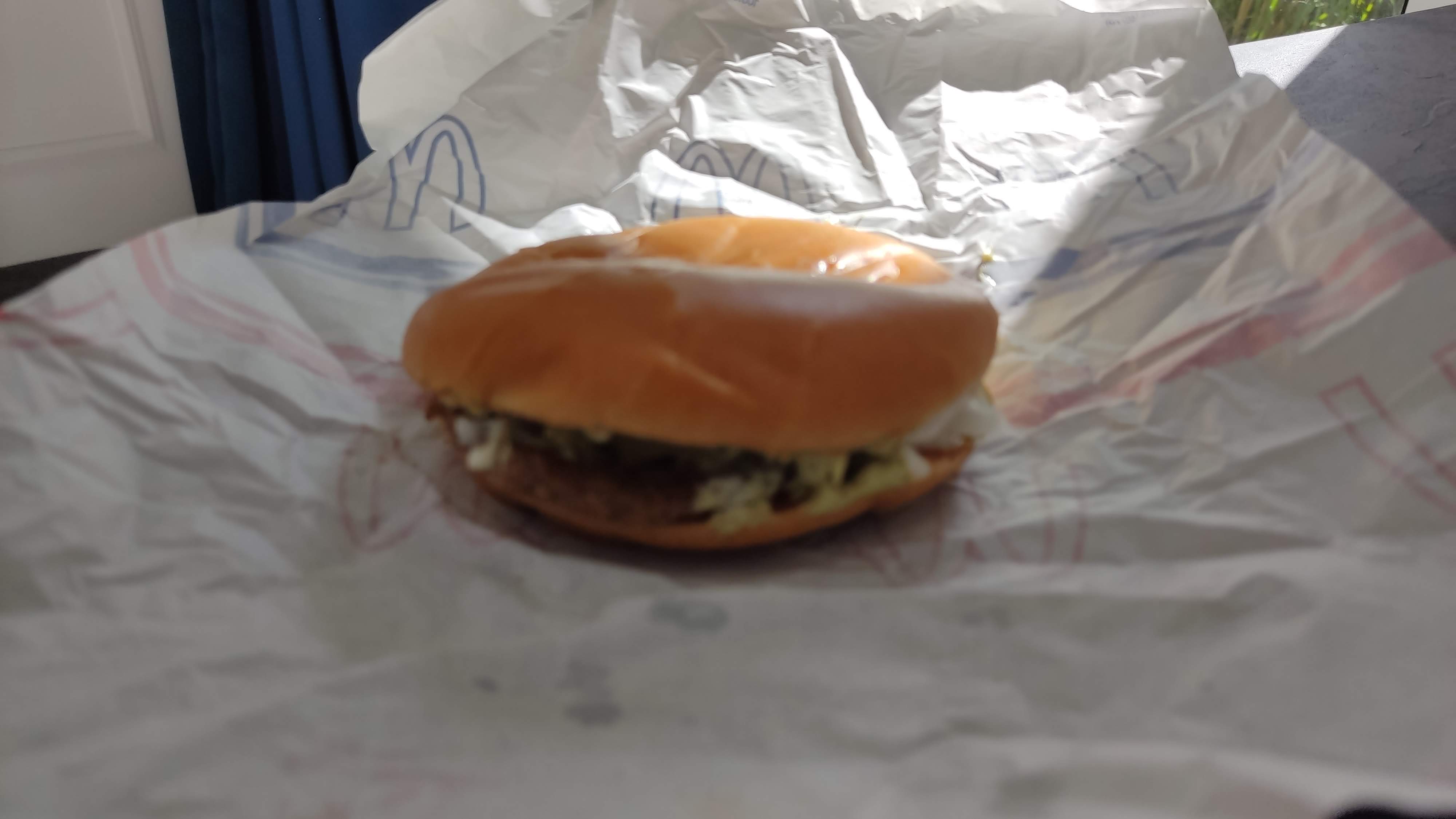 Jalapeño Burger: A Spicy Touch to Polish McDonald's Menu : Jalapeño burger in its open paper wrap with visible jalapeño slices